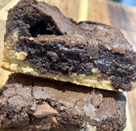 Two slices of brookie, a cookie based toped with gooey brownie.